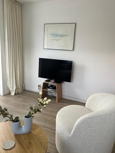 a living room with a chair and a tv at Ferienwohnung Wulf Sylt EG in Wenningstedt