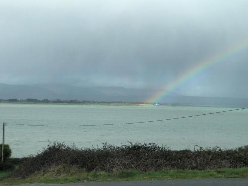 a rainbow over a large body of water at Cois Cuan in Ballynagaul