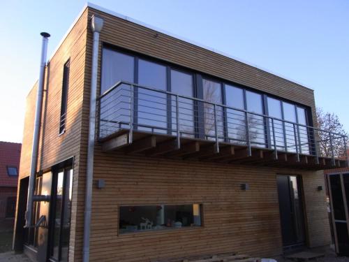 a house with a balcony on the side of it at Haus Charly Exklusives Architektenhaus Holzbauweise Fehmarn, strandnah in Fehmarn