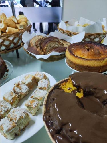 una tavola con diversi tipi di prodotti da forno e torte di Hotel Serra do Gandarela a Rio Acima