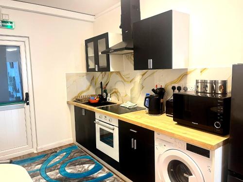 a kitchen with a sink and a washing machine at Bacton Coastal Retreat in Bacton