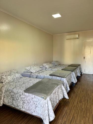 a row of three beds in a room at Cravinhos Park Hotel in Cravinhos