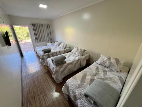 a room with three beds in a room at Cravinhos Park Hotel in Cravinhos