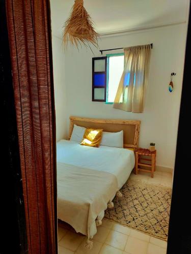 a bedroom with a bed and a window at Moroccan Boho Surf House in Agadir