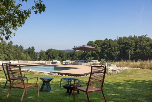two chairs and a table with an umbrella next to a pool at Villa Serena Appartement duplex de 170m2 
