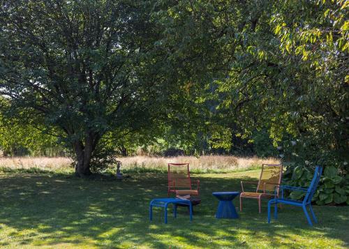 three chairs and a table under a tree at Villa Serena Appartement duplex de 170m2 