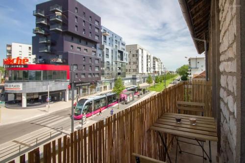 a balcony with a view of a city with a bus at Le Martre - Apt 4 Personnes, 2 ch, avec Balcon in Dijon