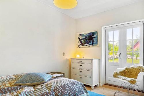 a bedroom with a bed and a dresser and a window at 5525-Svaneke-Bolshavn-19 in Svaneke