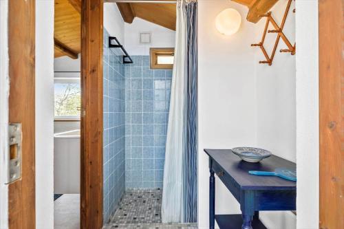 a bathroom with a blue tiled shower and a table at 6685-Allinge-Tejnvej-24 in Allinge