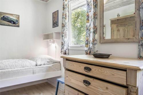 a bedroom with a bed and a dresser with a mirror at 9004-Hasle-Klympen-2 in Hasle