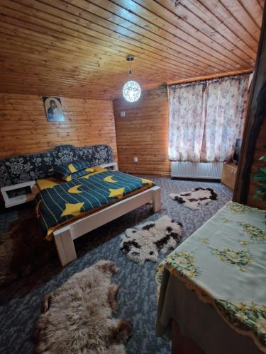 Un dormitorio con una cama y una oveja tendida en el suelo. en Cabana Micutu, en Sebeş