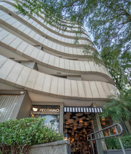 ein Gebäude mit einem Schild vor einem Laden in der Unterkunft George V Alto De Pinheiros in São Paulo