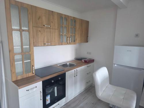 a kitchen with wooden cabinets and a sink and a chair at Lara in Bugojno