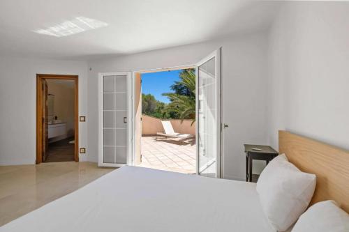 a bedroom with a bed and a view of a patio at Prestigious 5-star garden villa in Mougins