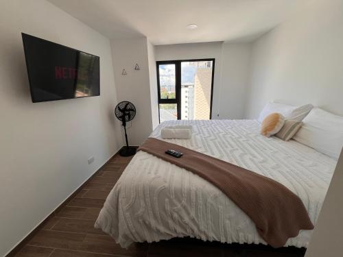 a bedroom with a large bed with a tv on the wall at Luxury High-Floor 3 Bedroom Apartment FREE Pool & Gym in Guatemala
