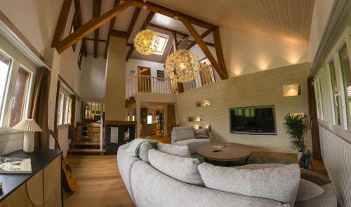 a living room with a couch and a tv at Villa Serena Appartement duplex de 170m2 