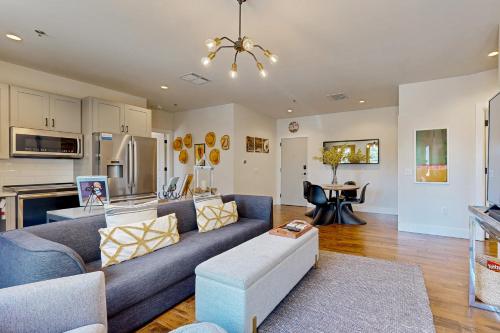 a living room with a blue couch and a kitchen at The 1865 #113 in Nashville