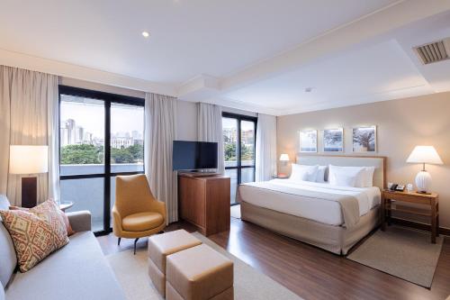 Großes Hotelzimmer mit einem Bett und einem TV in der Unterkunft George V Alto De Pinheiros in São Paulo