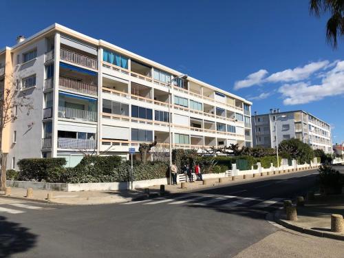 un grande edificio bianco con persone che lo circondano di Le Plein Sud a Le Grau-du-Roi