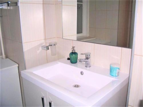 ein weißes Waschbecken mit einer grünen Flasche in der Unterkunft Spark Apartment in Budapest