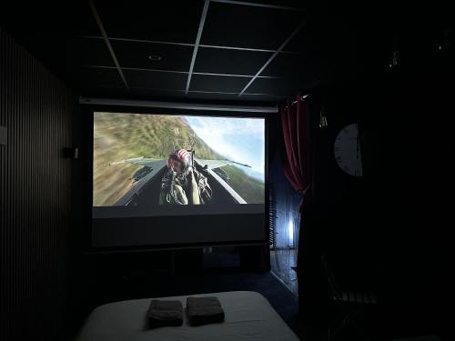 a tv in a dark room with a video game on it at Cocon Jacuzzi et cinéma 4K B in Bordeaux