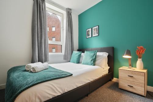 a bedroom with a bed with blue walls and a window at 2 BR Apt By Eason Stays Short Lets & Serviced Accommodation Kelham Island Sheffield With Free Wifi in Midland