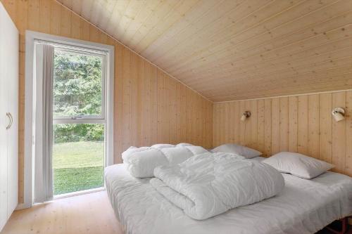 un grande letto bianco in una stanza con una finestra di LK2166-Lokken-Raevevej-24 a Løkken