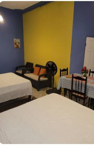 a room with two beds and a table and chairs at sleeps 7 plus private parking apartment near Yallahs in St Thomas Jamaica 