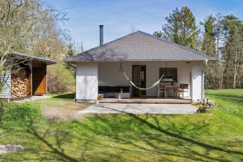a small white house with a patio in a yard at LF16311-Nibe-Pirken-19 in Nibe