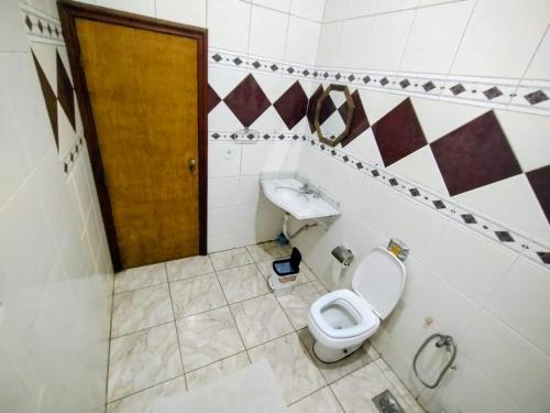 a bathroom with a toilet and a sink at Pousada Santa Terezinha in Aparecida