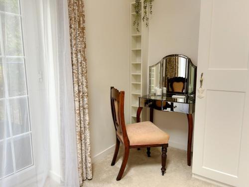 a chair sitting next to a desk with a mirror at Peak District Period Property near Chatsworth House in Bakewell