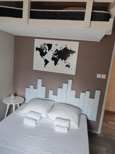 a bedroom with a bed with a world map on the wall at Charming studio close to Léguevin Colomiers ring road in Fontenilles