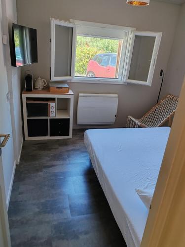 a small bedroom with a bed and a window at Charming studio close to Léguevin Colomiers ring road in Fontenilles