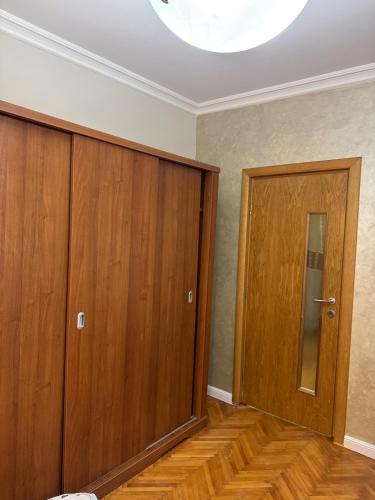 an empty room with two wooden doors and wood floors at Apartment for rent in Baile Herculane in Băile Herculane