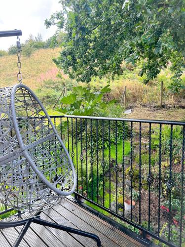 a swinging bench on a balcony with a garden at Peak District Period Property near Chatsworth House in Bakewell