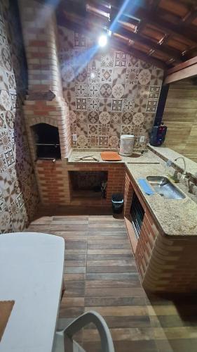 a kitchen with a sink and a brick wall at Casa de temporada do Mr Bim in Cabo Frio
