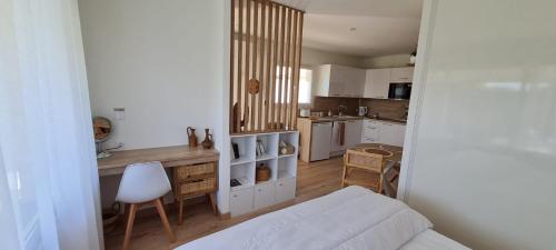 a living room with a white couch and a kitchen at Le Mulaty Cozy in Tossiat
