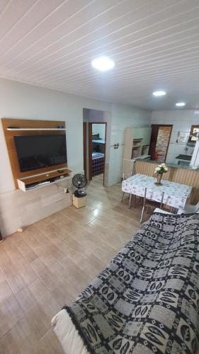 a living room with a large bed and a television at Casa de temporada do Mr Bim in Cabo Frio
