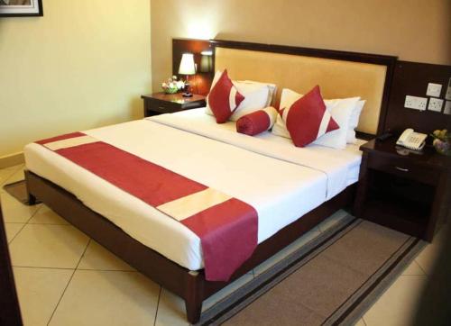 Un dormitorio con una cama grande con almohadas rojas. en Bridgeview Hotel and Conference Centre, en Lilongwe