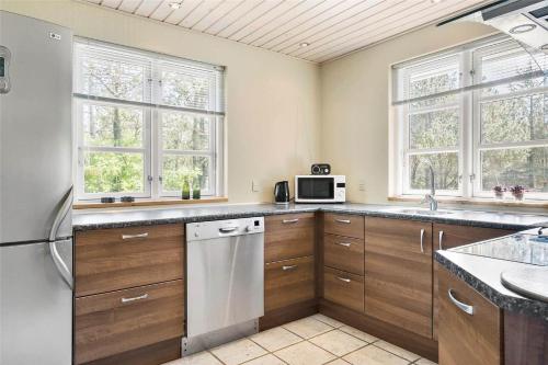 a kitchen with wooden cabinets and a white refrigerator at LF584-Hurup-Thy-Haettemagevej-4 in Sindrup