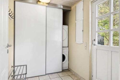 a laundry room with a washing machine and a door at LF584-Hurup-Thy-Haettemagevej-4 in Sindrup