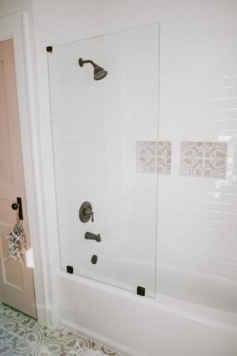 a shower with a glass door in a bathroom at The Pink House in Downtown Clarksville in Clarksville