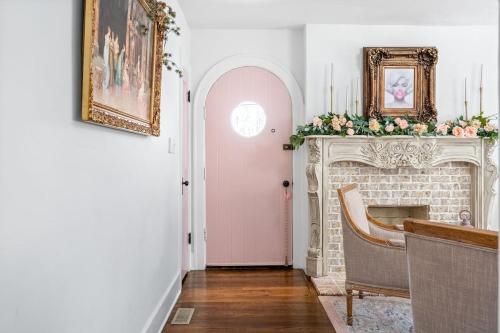 a living room with a fireplace and a pink door at The Pink House in Downtown Clarksville in Clarksville