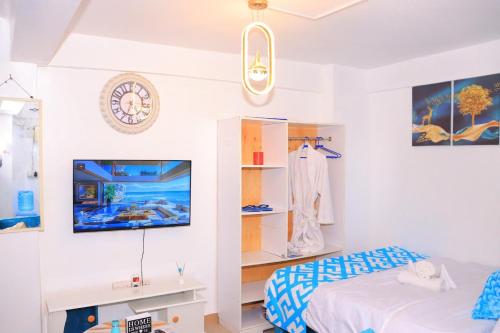 a bedroom with a bed and a clock on the wall at The Blue Haven in Nairobi