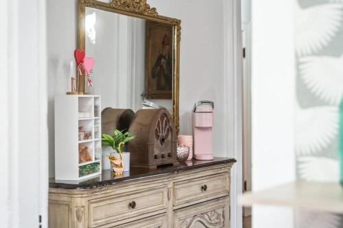 a wooden dresser with a mirror on top of it at The Pink House in Downtown Clarksville in Clarksville