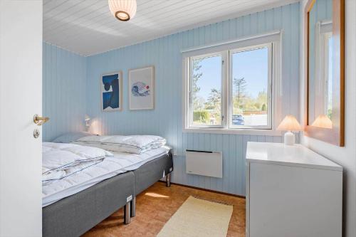 Dormitorio azul con cama y lavamanos en 3664-Nexo-Strandvolden-11, en Neksø