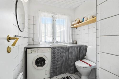 Un baño con lavadora y un inodoro. en 3664-Nexo-Strandvolden-11, en Neksø