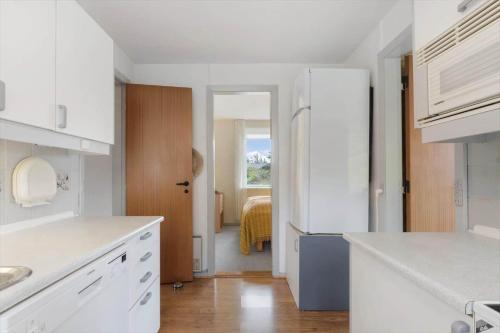 una cucina bianca con frigorifero e un corridoio di LF16234-Logstor-Gerdasvej-6 a Løgsted