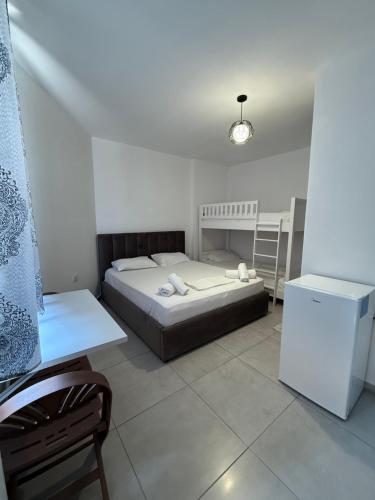 a small bedroom with a bed and a refrigerator at Guest House Kloen in Vlorë