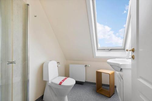 a bathroom with a toilet and a sink and a window at 5613-Allinge-Bohnebakken-21-Lejl-1 in Allinge